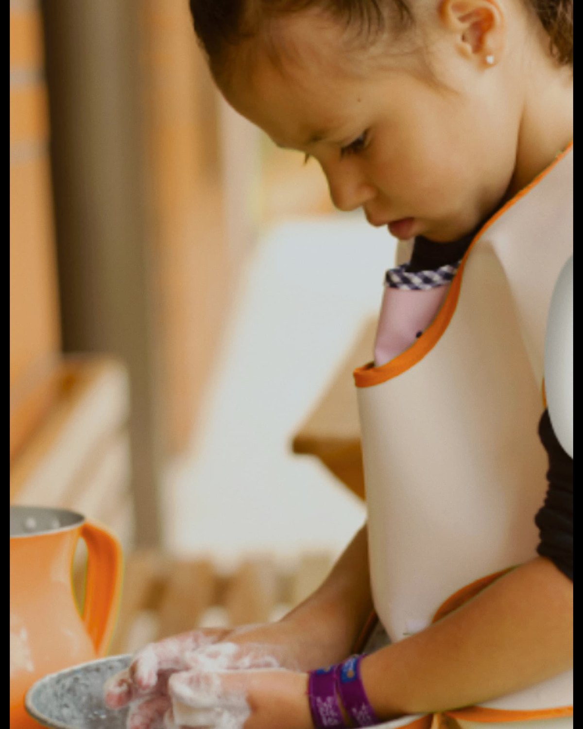A child pouring water during a practical life activity in a Montessori classroom
